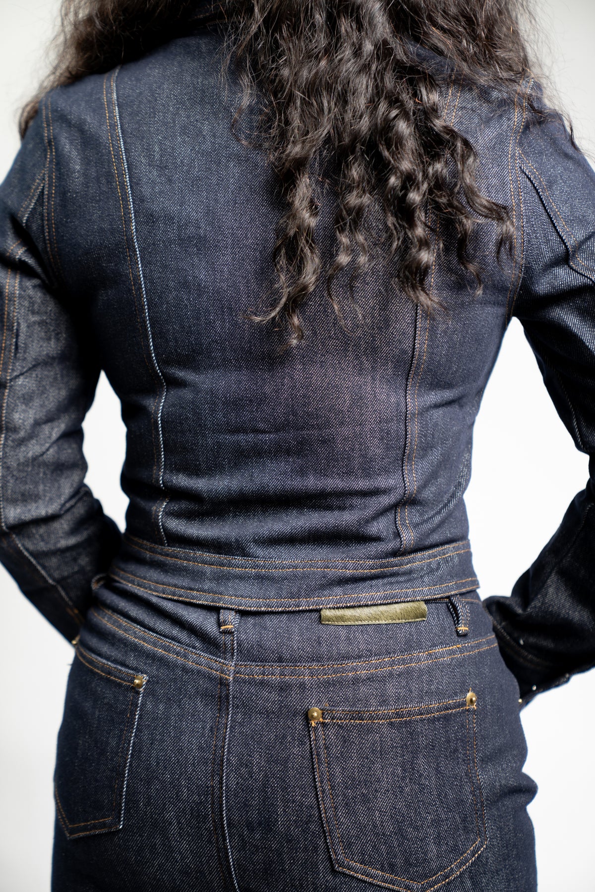Three-quarter view of the indigo fitted denim jacket styled as a matching set