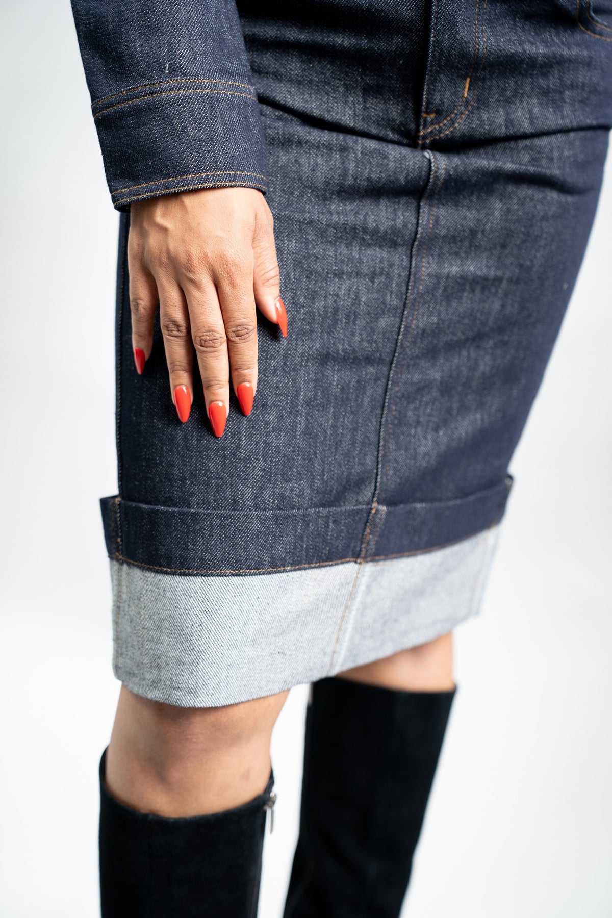 Close-up of the deep folded cuff and lighter underside of the indigo denim skirt