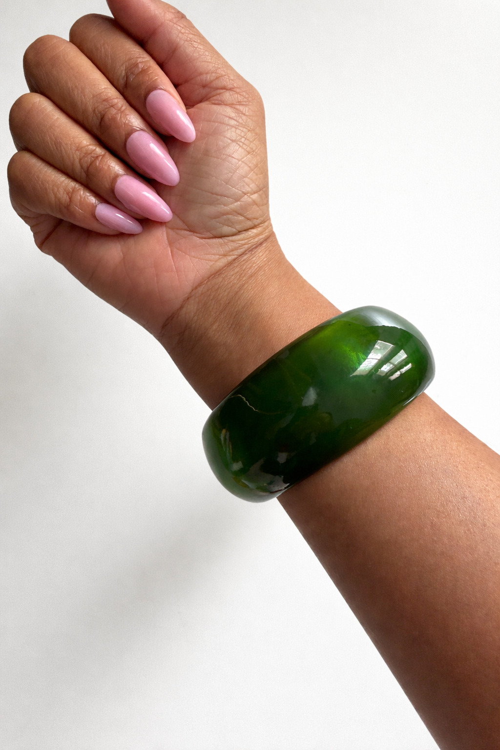 Green bracelet on a wrist with a white background