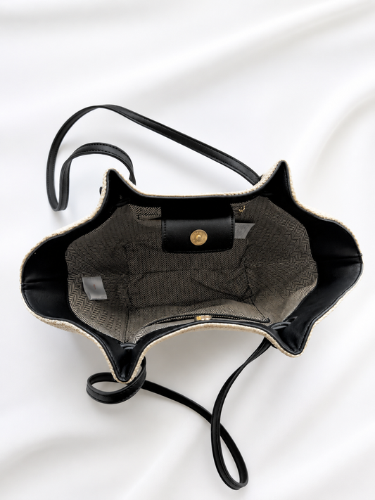 Black leather handbag with gold accents on a white background