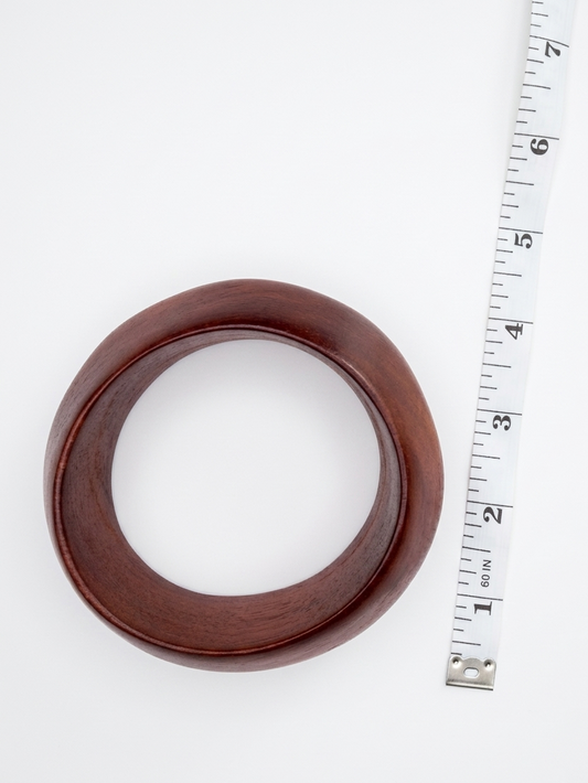 Brown rubber gasket with a ruler for scale on a white background