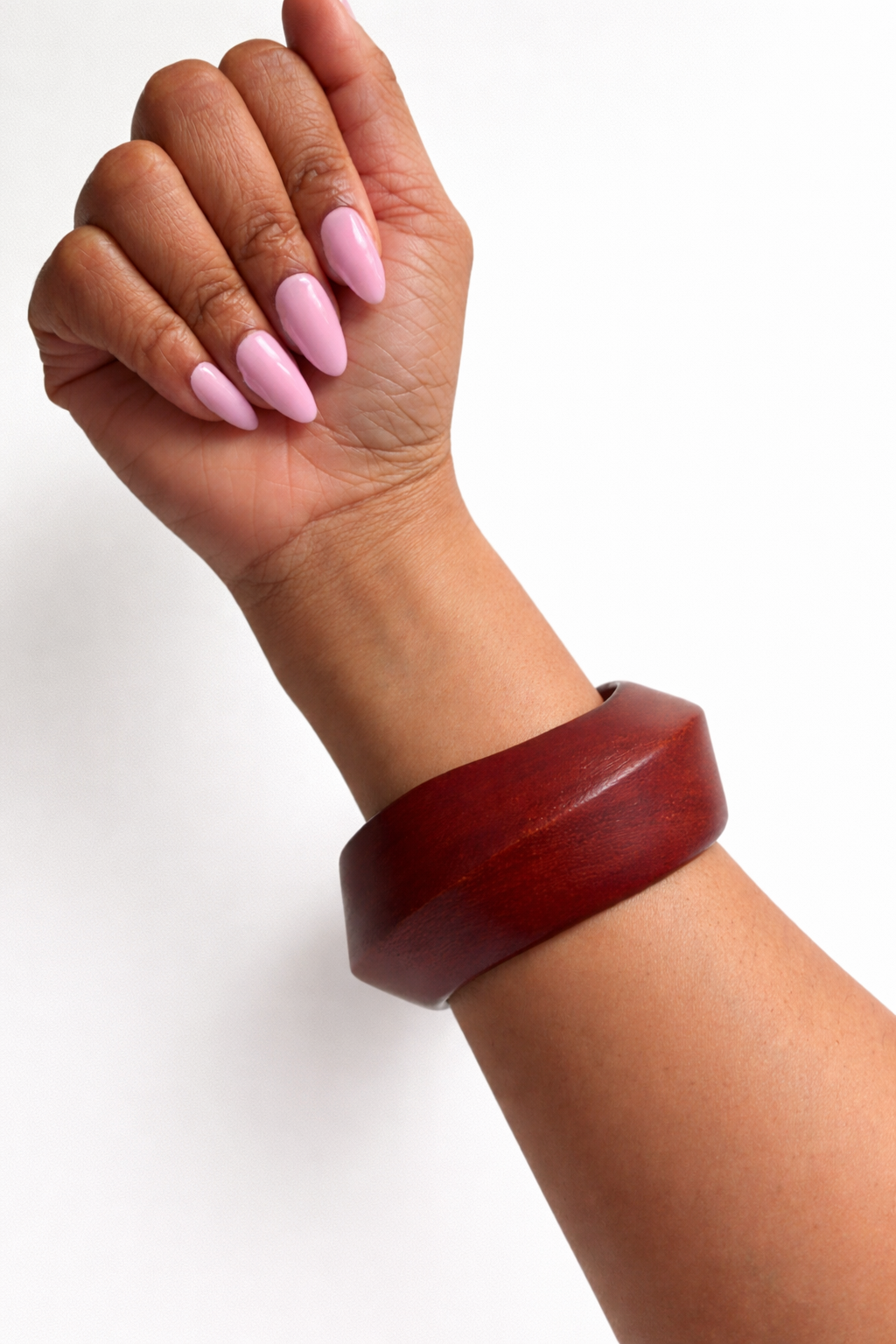 Hand wearing a wooden bracelet on a white background